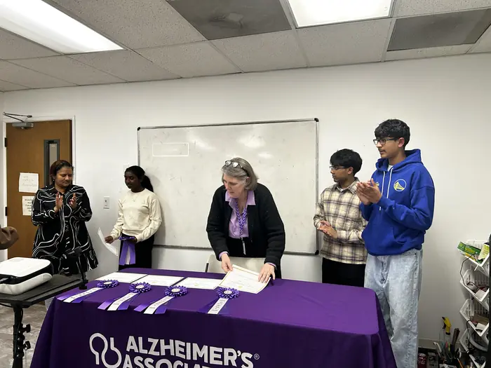 A group photo of competitors and organisers at the Alzheimer's Association table.