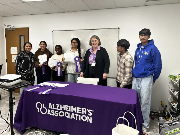 A group of competitors and organisers beside the Alzheimer's Association table.