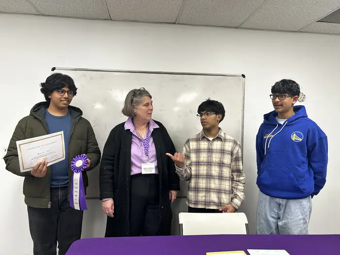 Certificate winners standing together with an organiser.