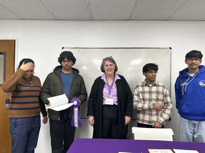 Certificate winners and an organiser holding certificates at the event.